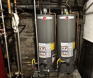 Two tank water heaters installed in a mechanical room